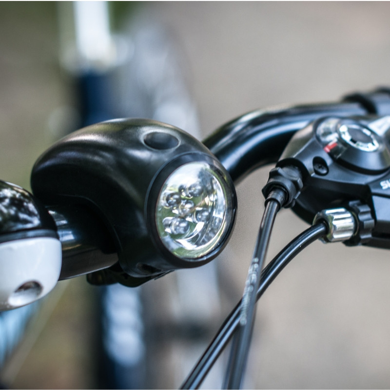 Lampka rowerowa przednia CYCLOP, zamocowana na kierownicy